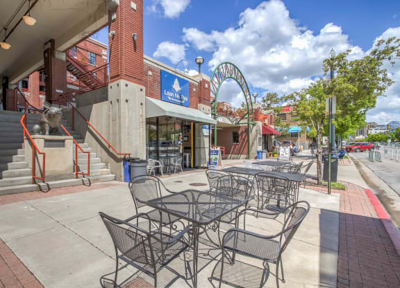 a patio with tables and chairs in front of a building
