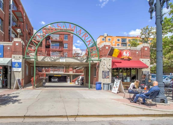 a city street with people sitting at tables in front of a building