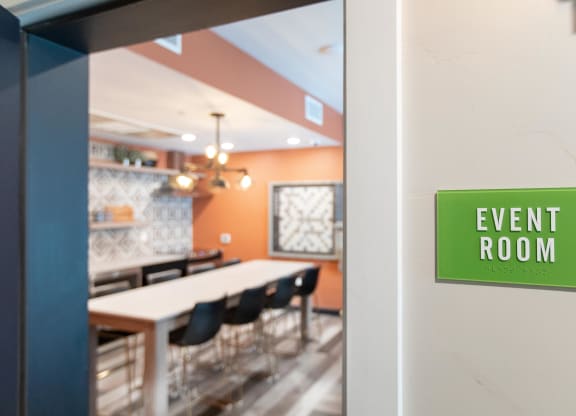 an event room with a table and chairs and a green sign that reads event room
