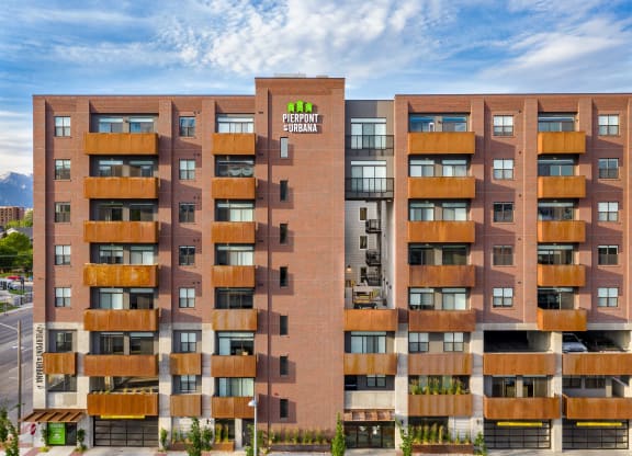 a large apartment building with a green logo on the side of it