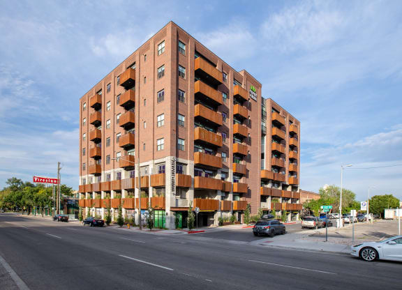 a large brick building with balconies on a city street