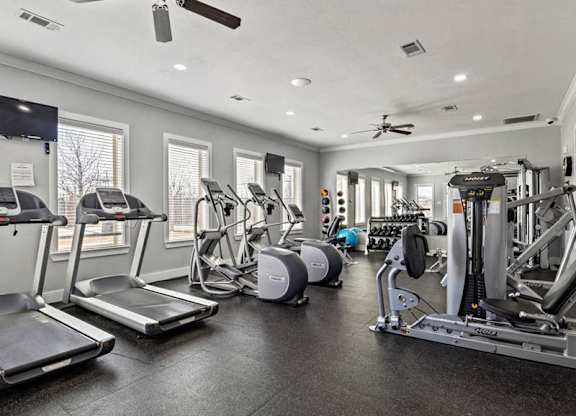 A spacious gym with treadmills, elliptical machines, and other exercise equipment.