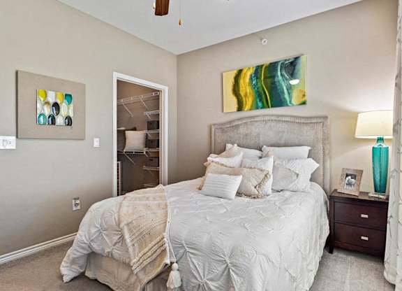 A bedroom with a large bed and a ceiling fan.
