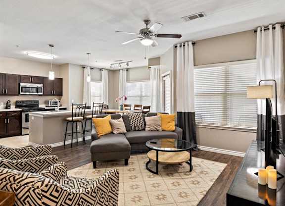A living room with a grey couch and a patterned rug.