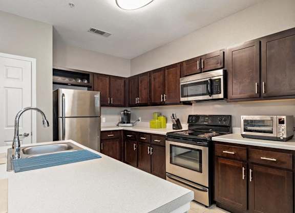 A kitchen with brown cabinets and a white counter.