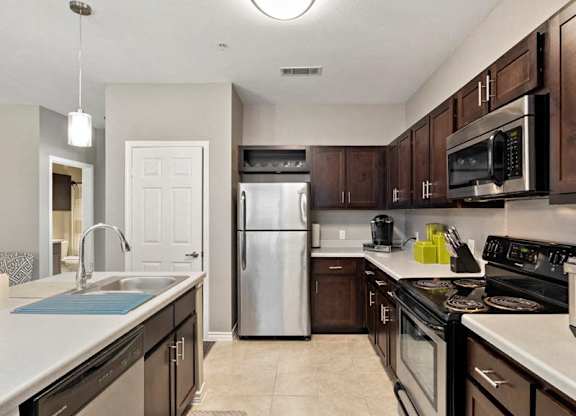 A kitchen with brown cabinets and a white counter.