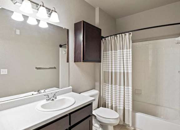 A bathroom with a white sink and a white toilet.