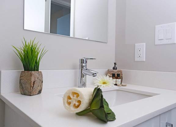 a white bathroom with a sink and a mirror