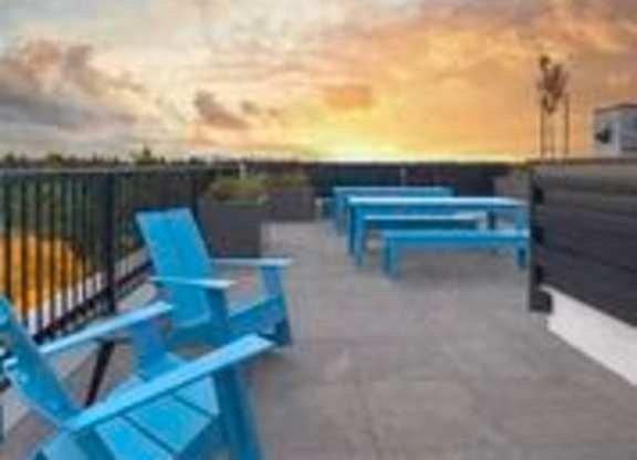 View outside on rooftop lounge with Blue Adirondack Chairs at Arabella Apartment Homes, Shoreline, WA, 98155