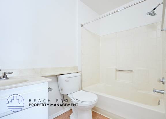 A white toilet sits next to a sink in a bathroom.