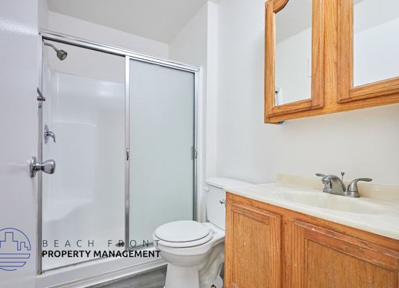 A white toilet sits next to a glass shower door in a bathroom.