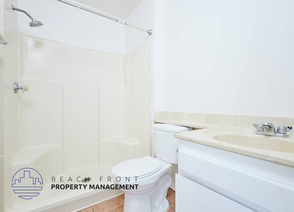 A white toilet sits next to a sink in a bathroom.