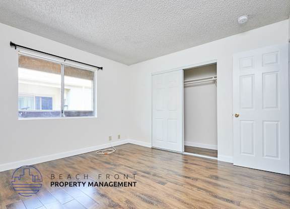 A room with a white door and a window with blinds.