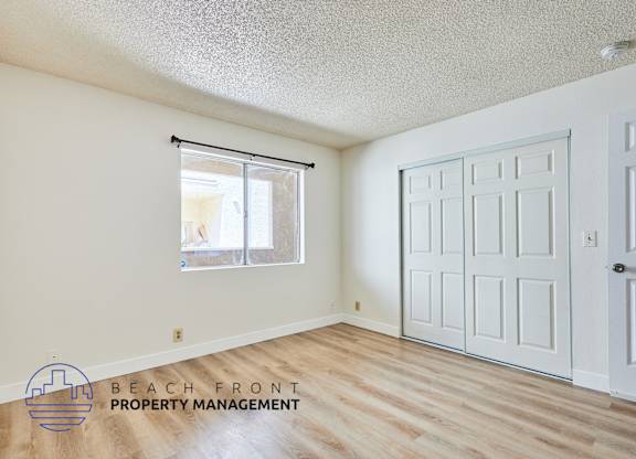 A room with a white door and a window with blinds.