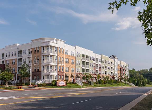 a street view of an apartment complex with a blue sky in the background