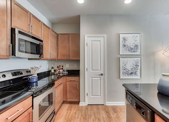 a kitchen with wood cabinets and black countertops