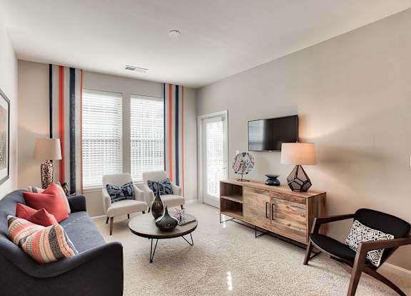 a living room with a couch chairs and a tv