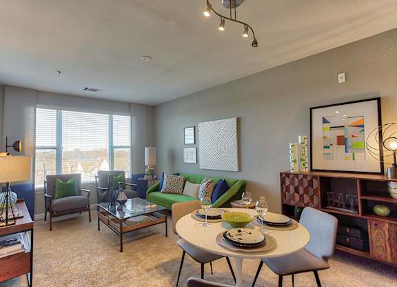 a living room with a table and chairs in front of a window