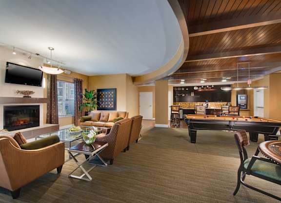 a living room filled with furniture and a pool table