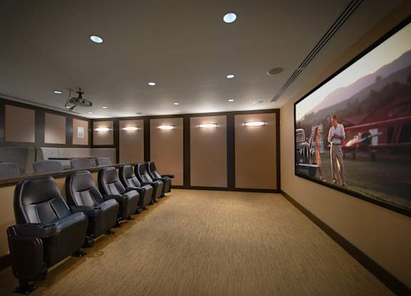 a screening room with leather chairs and a large screen