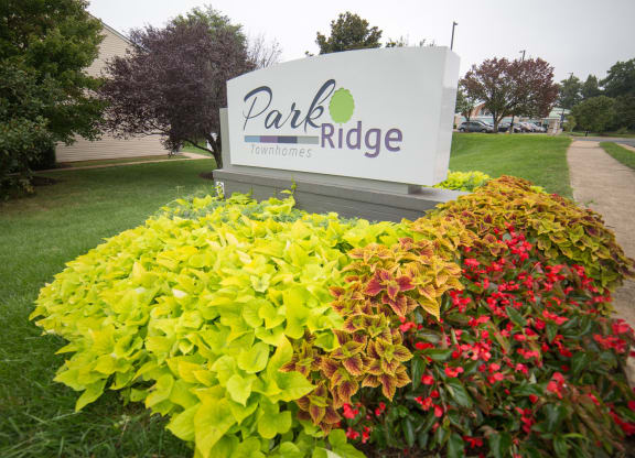 Community sign in the middle of a flower bed.