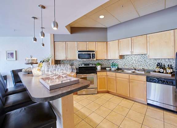 A kitchen with a bar and a microwave above the stove.