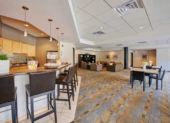 A dining area with a bar, tables, and chairs.