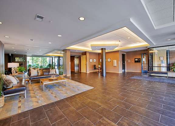 A spacious lobby with brown leather couches.