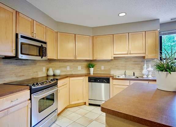 A kitchen with wooden cabinets and a stove top oven.