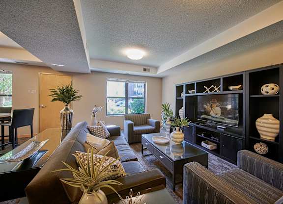 A living room with a brown couch, chairs, and a coffee table.