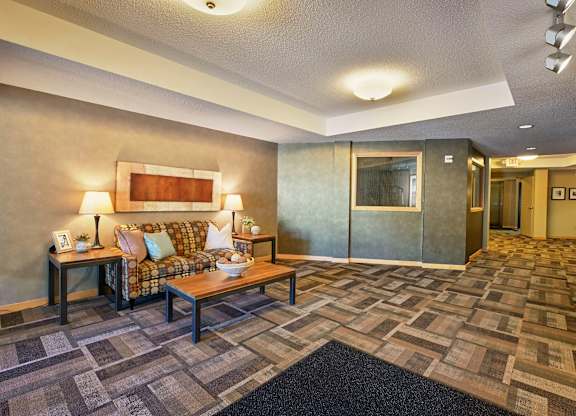 A lobby with a couch and coffee table.