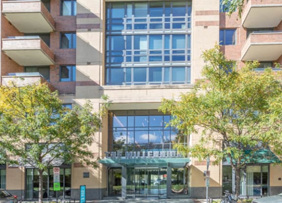 a building with large windows and trees in front of it at The Millennium, Arlington, 22202