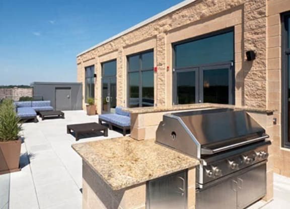 a patio with a grill and lounge chairs at The Millennium, Virginia, 22202
