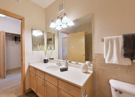 A bathroom with a vanity, a mirror, and a towel.