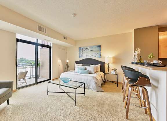 A living area with a bed, a coffee table, and a chair.