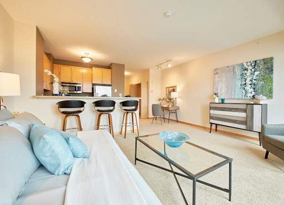 A living space with a white couch and a glass coffee table.