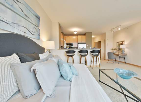A modern living space with a sofa, coffee table and kitchen area in the background.