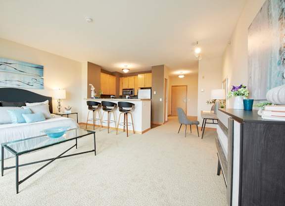A modern living space with a sofa, coffee table and kitchen area in the background.