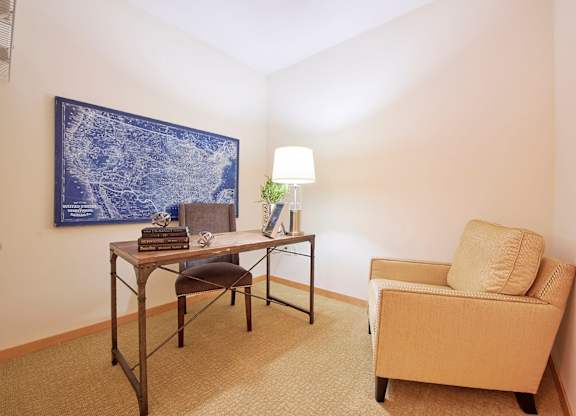 A room with two chairs, a desk, and a painting on the wall.