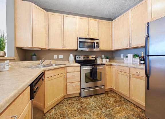 A kitchen with wooden cabinets and a tile floor.