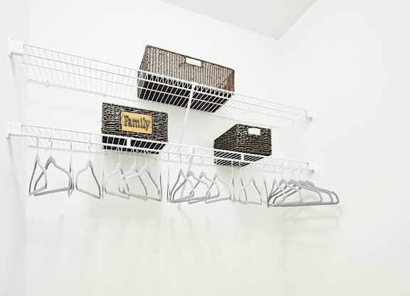 A wall with wire shelves on it.
