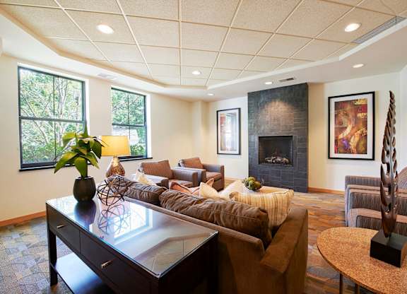 A living room with a fireplace, a couch, and chairs.