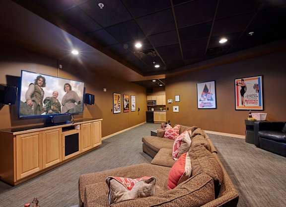 A room with a large couch and a television.