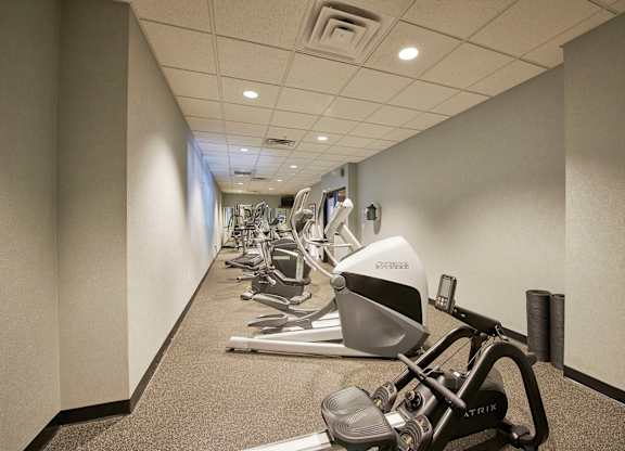 An exercise area with a row of cardio equipment.
