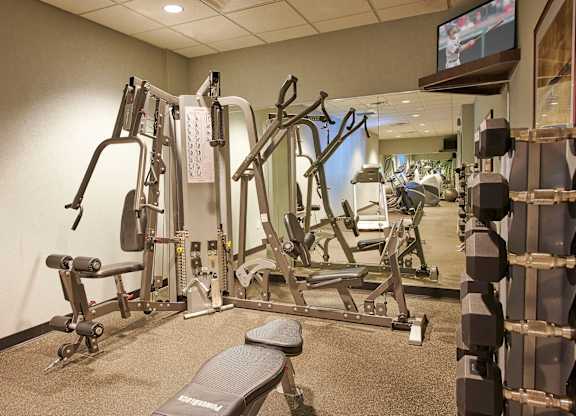 A gym with a variety of equipment including a flat screen TV.