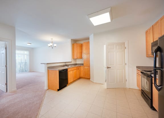an empty kitchen with a door to the living room