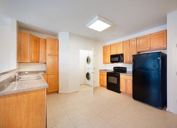 a kitchen with black appliances and wooden cabinets
