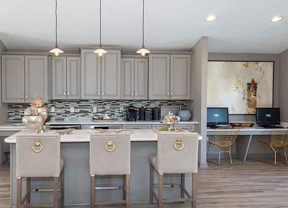 gray cabinets with large island, pendant lighting and white bar stools