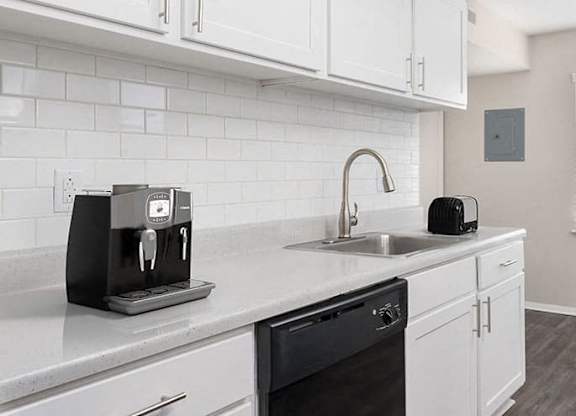 apartment kitchen with white cabinets and black appliances