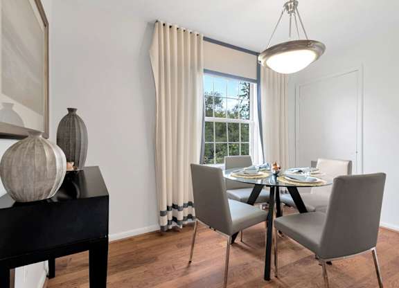 a dining room with a table and chairs and a window